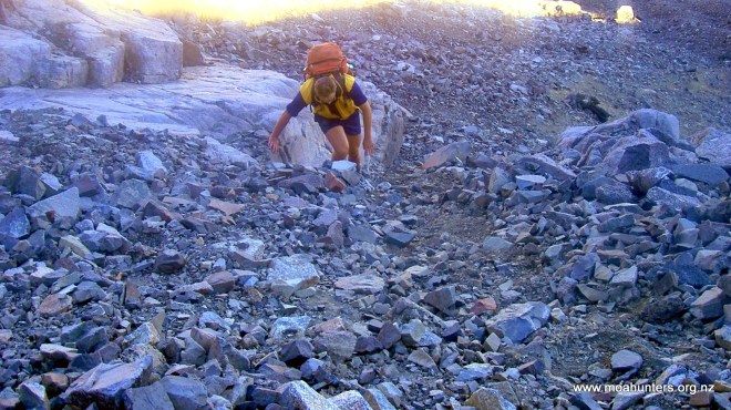 Chris grunting up a steep rocky slope